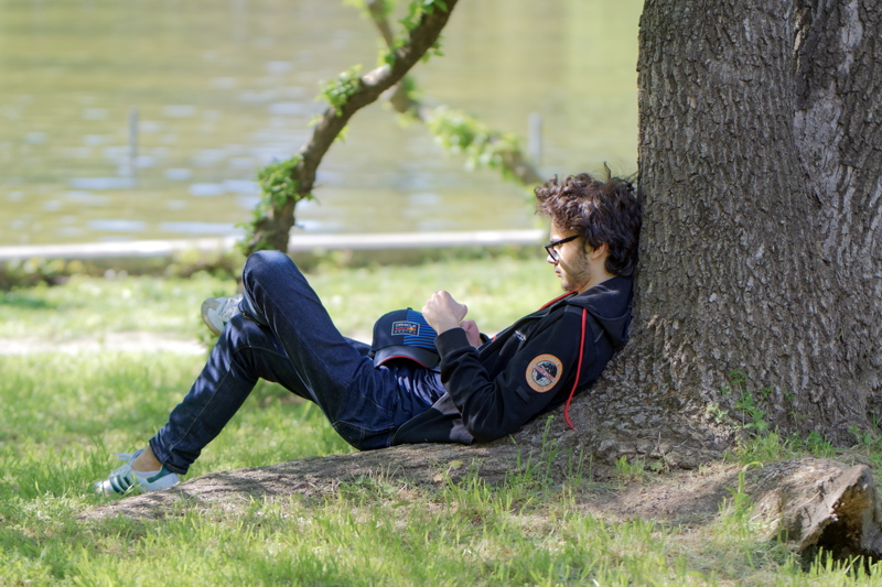 Boy leaning by a tree trunk